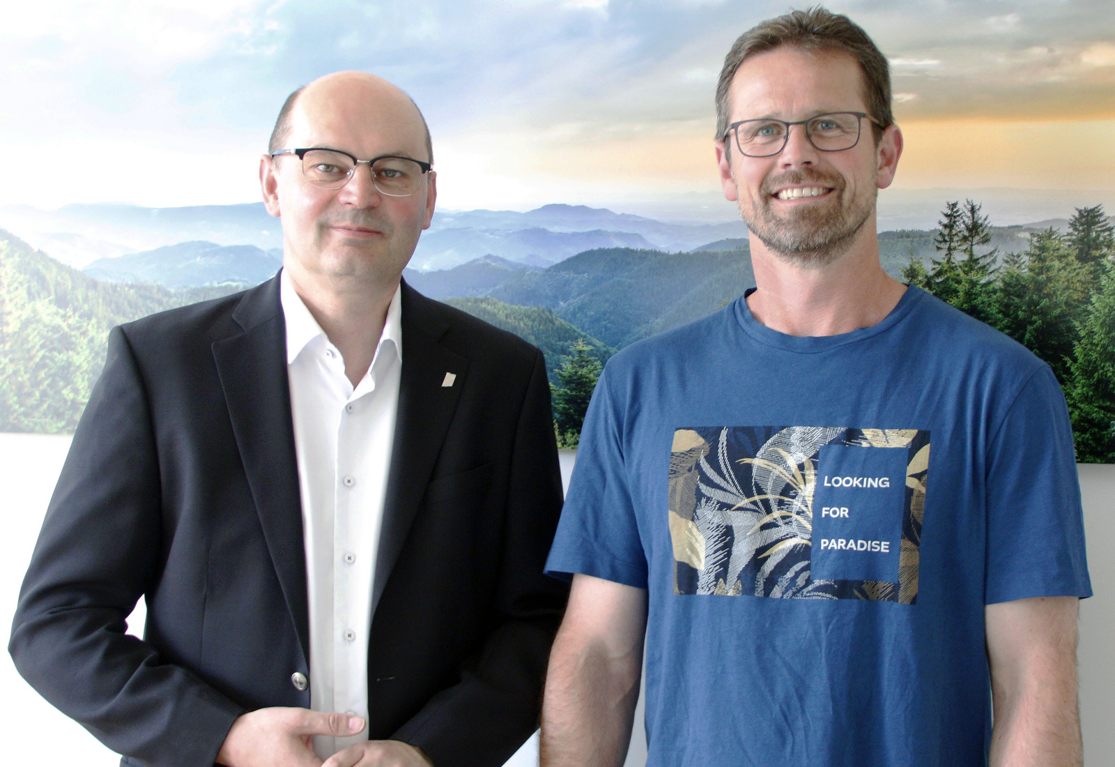 Rektor Prof. Dr. Stephan Trahasch (links) und Christoph Wieland (rechts) vor einem Schwarzwaldbild.