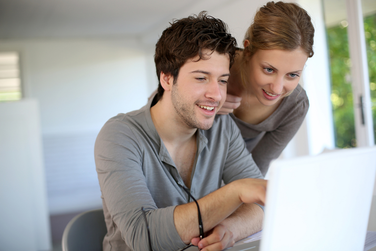 Eine Mann und eine Frau schauen auf einen Laptop