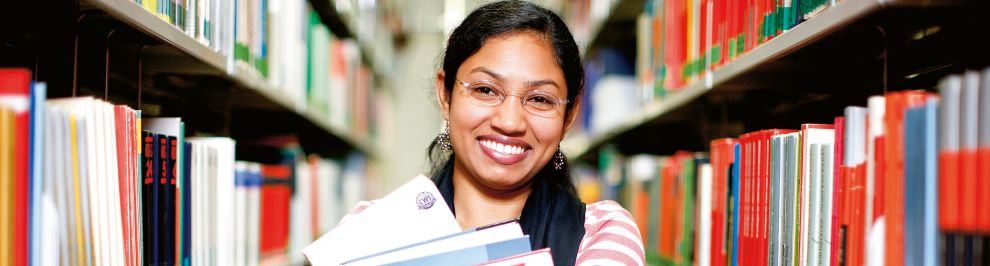Junge Frau zwischen zwei Bücherregalen