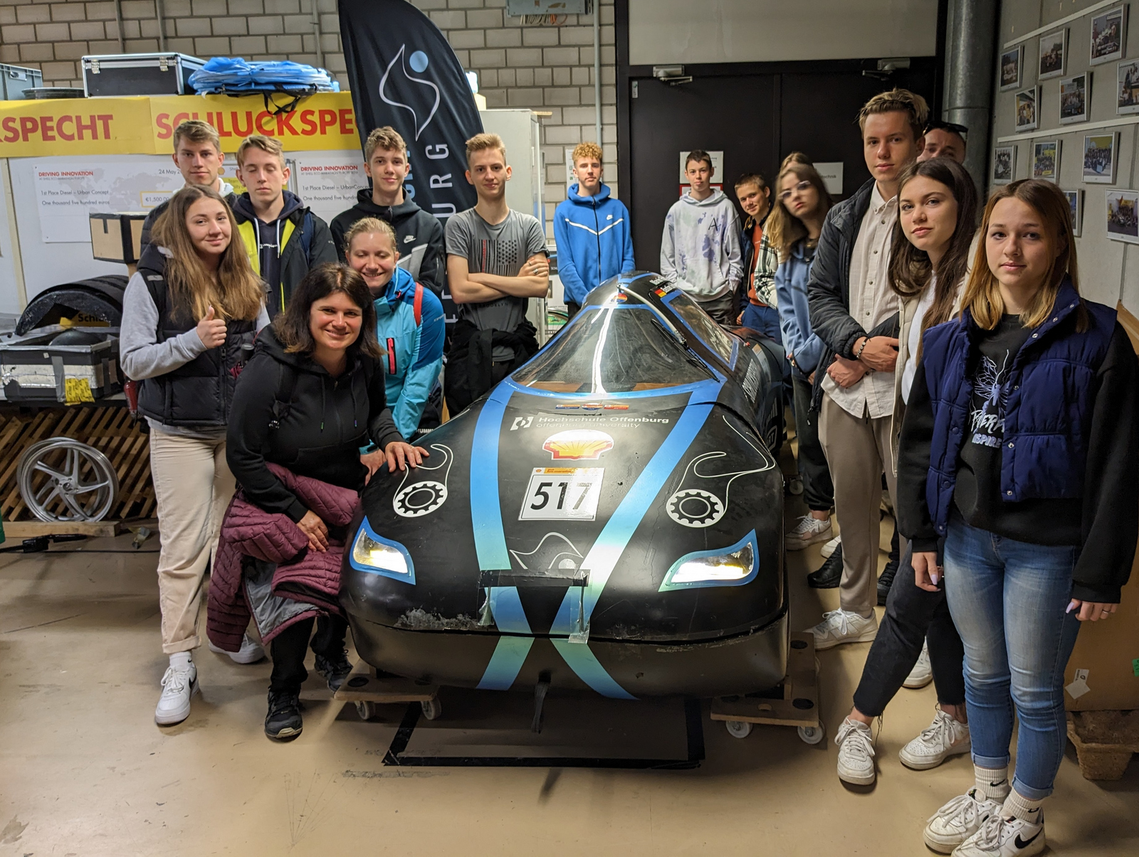 Die jungen Erwachsenen aus Slowenien stehen um ein Niedrigenergiefahrzeug des Teams Schluckspecht herum