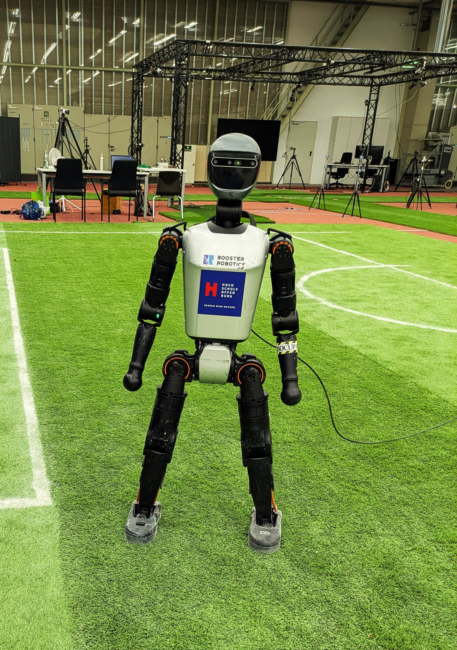 Ein humanoider Roboter steht auf einem Fußballfeld.
