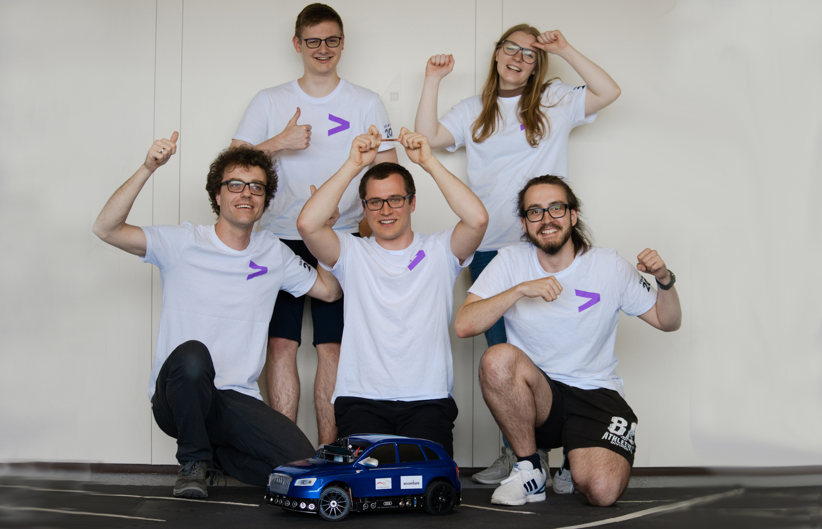Gruppenbild der jubelnden Teammitglieder, die in München dabei waren, mit Auto