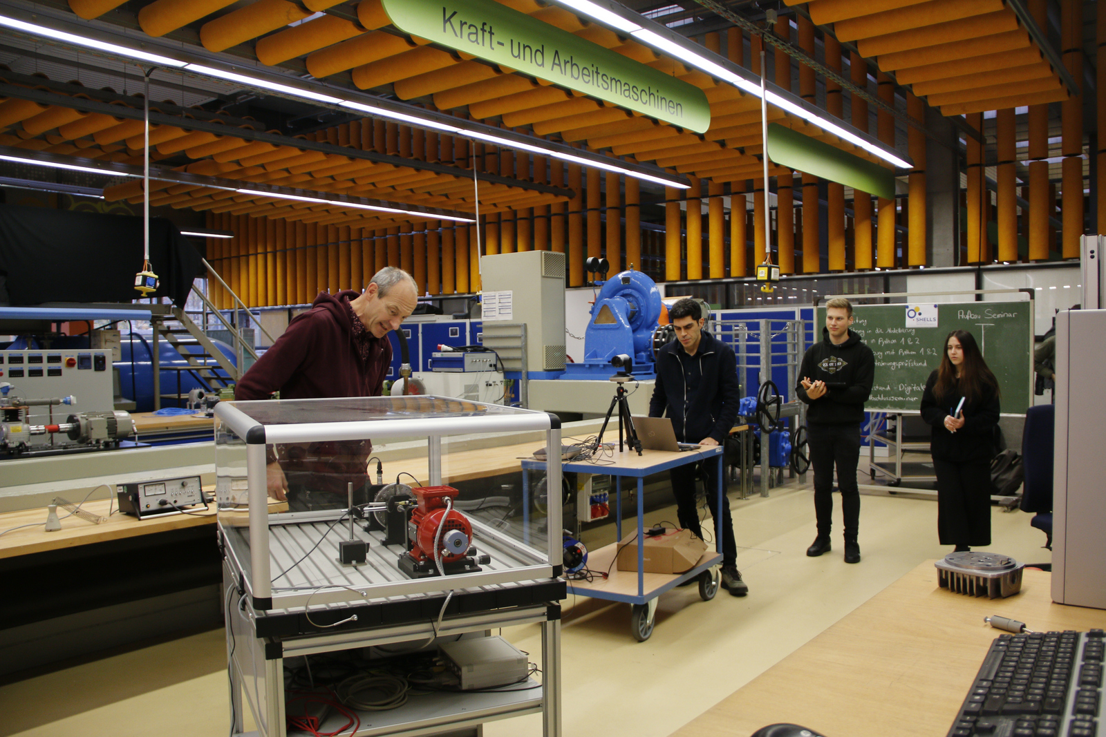 Gruppe steht im Labor um den Lavalläufer herum, es wird gefilmt