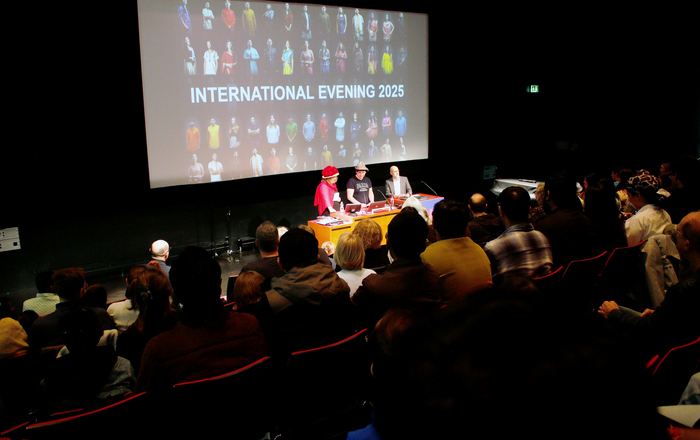 Drei menschn stehen vor einer Leinwand an einem rednerpult