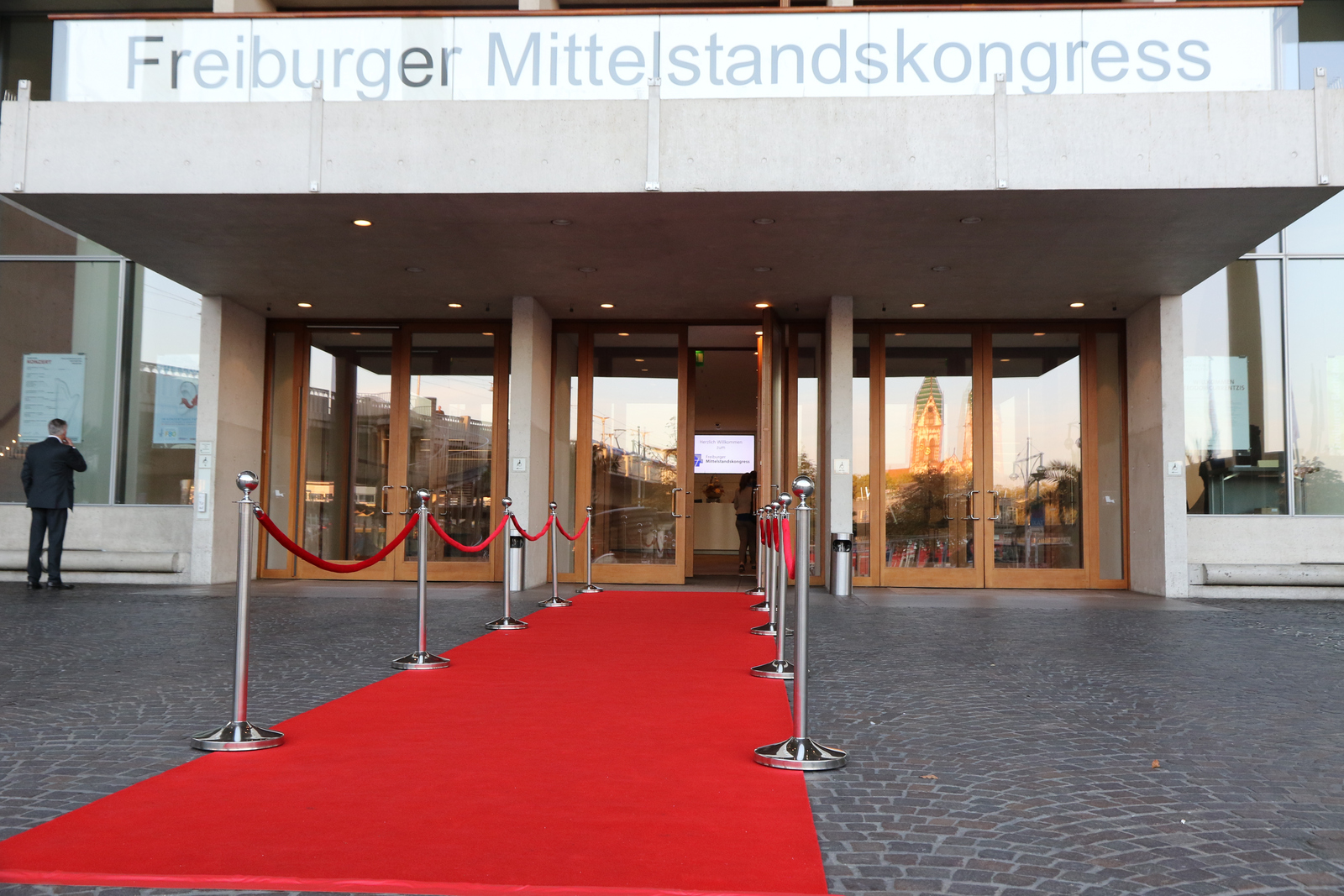 Die geöffnete Eingangstür zum Freiburger Mittelstandskongress  vor der ein roter Teppich ausgerollt ist