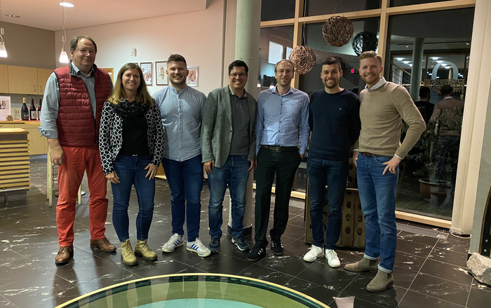 Sechs Männer und eine Frau stehen im Halbkreis im Weingut Schloss Ortenberg