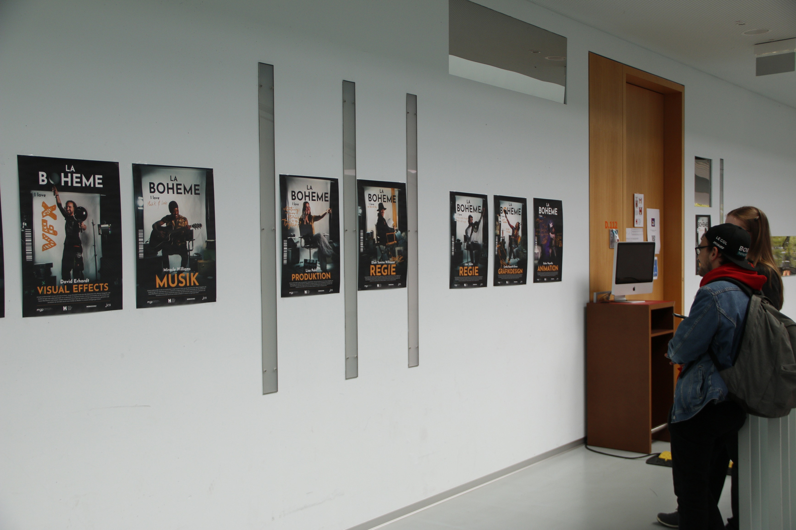 Menschen betrachten Filmplakate an der Wand