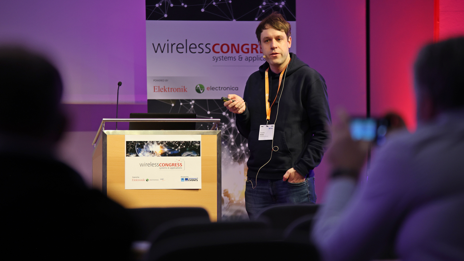 Dominik Welte als Redner auf dem Wireless Congress Dominik Welte als Redner neben einem Rednerpult