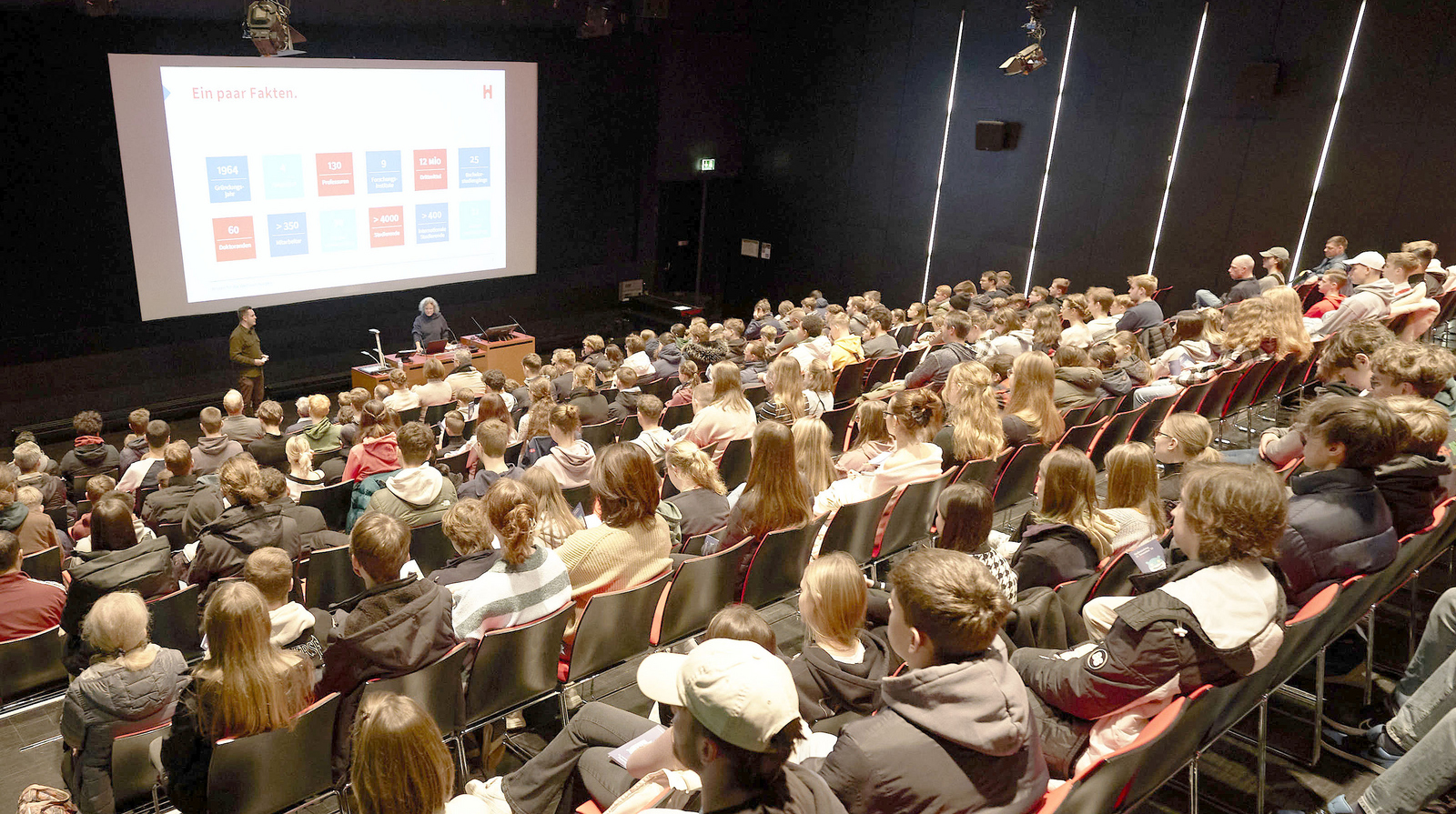 Schülerinnen und Schüler sitzen im Hörsaal