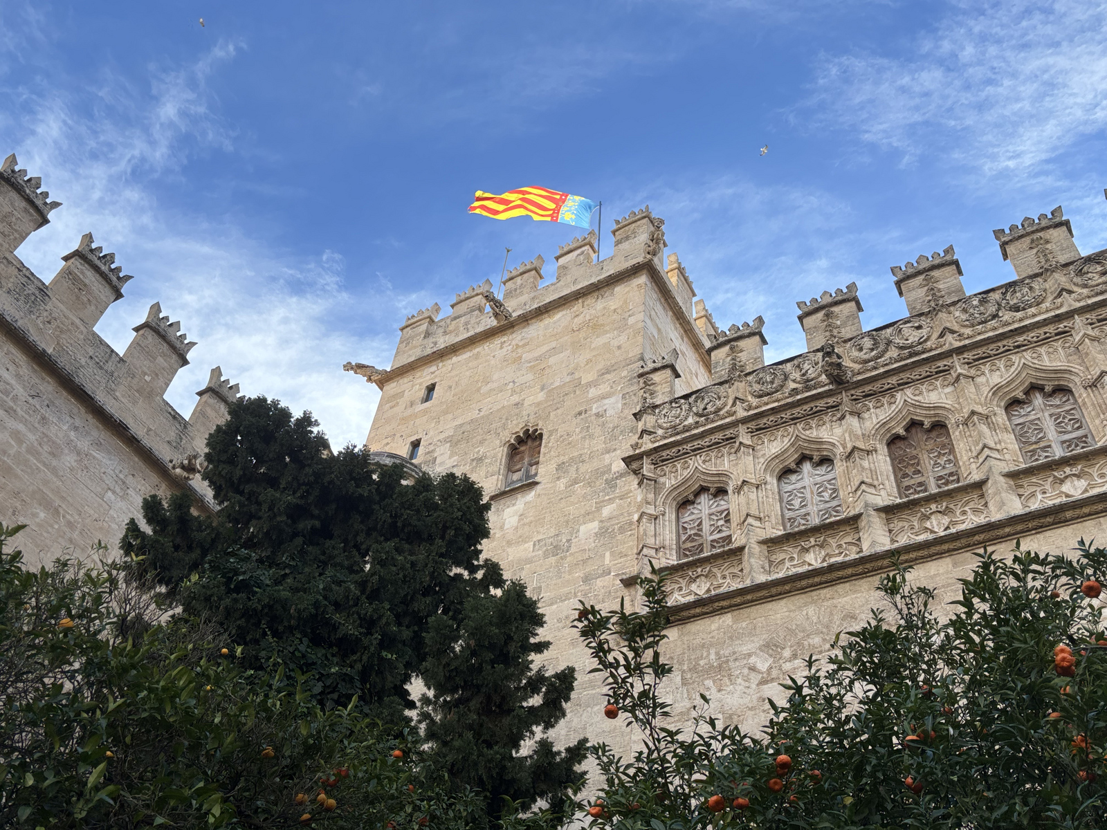 Eine altes Gebäude mit Zinnen auf den Außenmauern und einem Turm auf dem eine Fahne weht