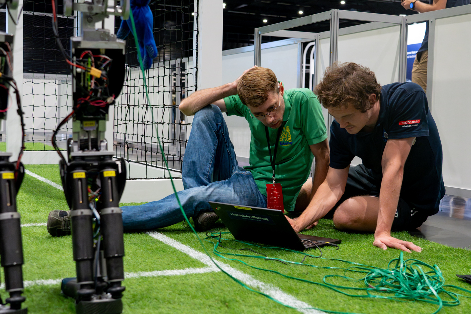 Team auf dem Rasen sitzend bei der Arbeit am Laptop