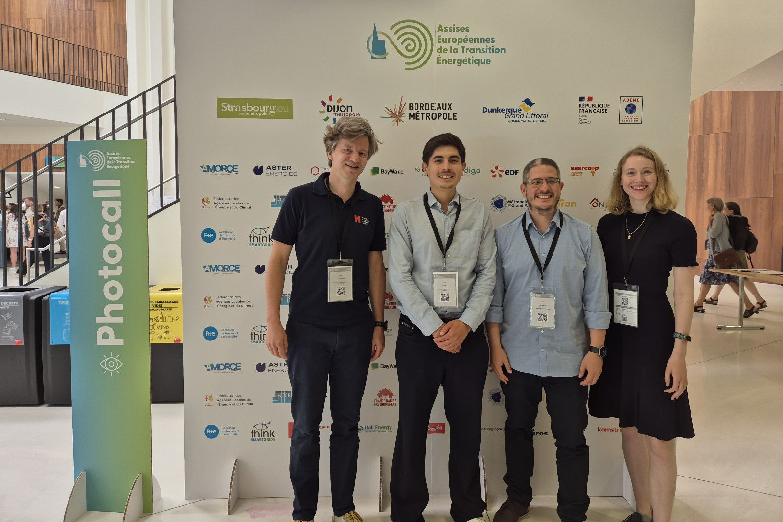Drei Männer und eine Frau stehen vor einer Stellwand mit den Logos der Beteiligten der Energiewendekonferenz