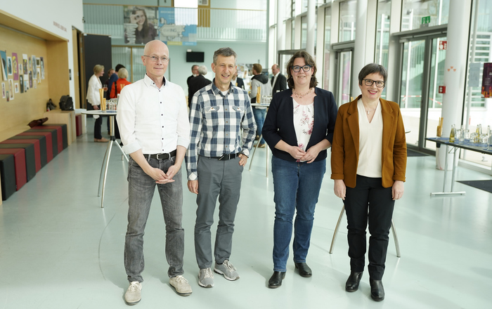 Die Ausgezeichneten Tom Rüdebusch, Harald Wiedemann, Anne Najderek und Eva Decker stehend, von links, im Foyer von Gebäude D.