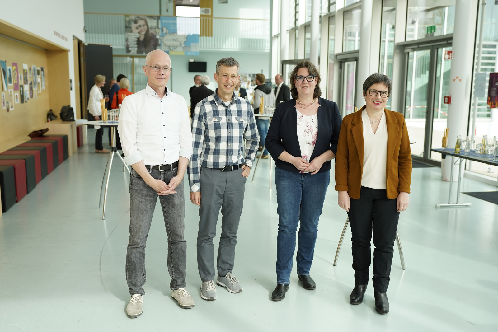 Die Ausgezeichneten Tom Rüdebusch, Harald Wiedemann, Anne Najderek und Eva Decker stehend, von links, im Foyer von Gebäude D.