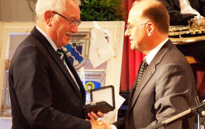 Michael Roschach (links) mit der Ehrenmedaille in der linken Hand schüttelte Prof. Dr. Winfried Lieber (rechts) die Hand 