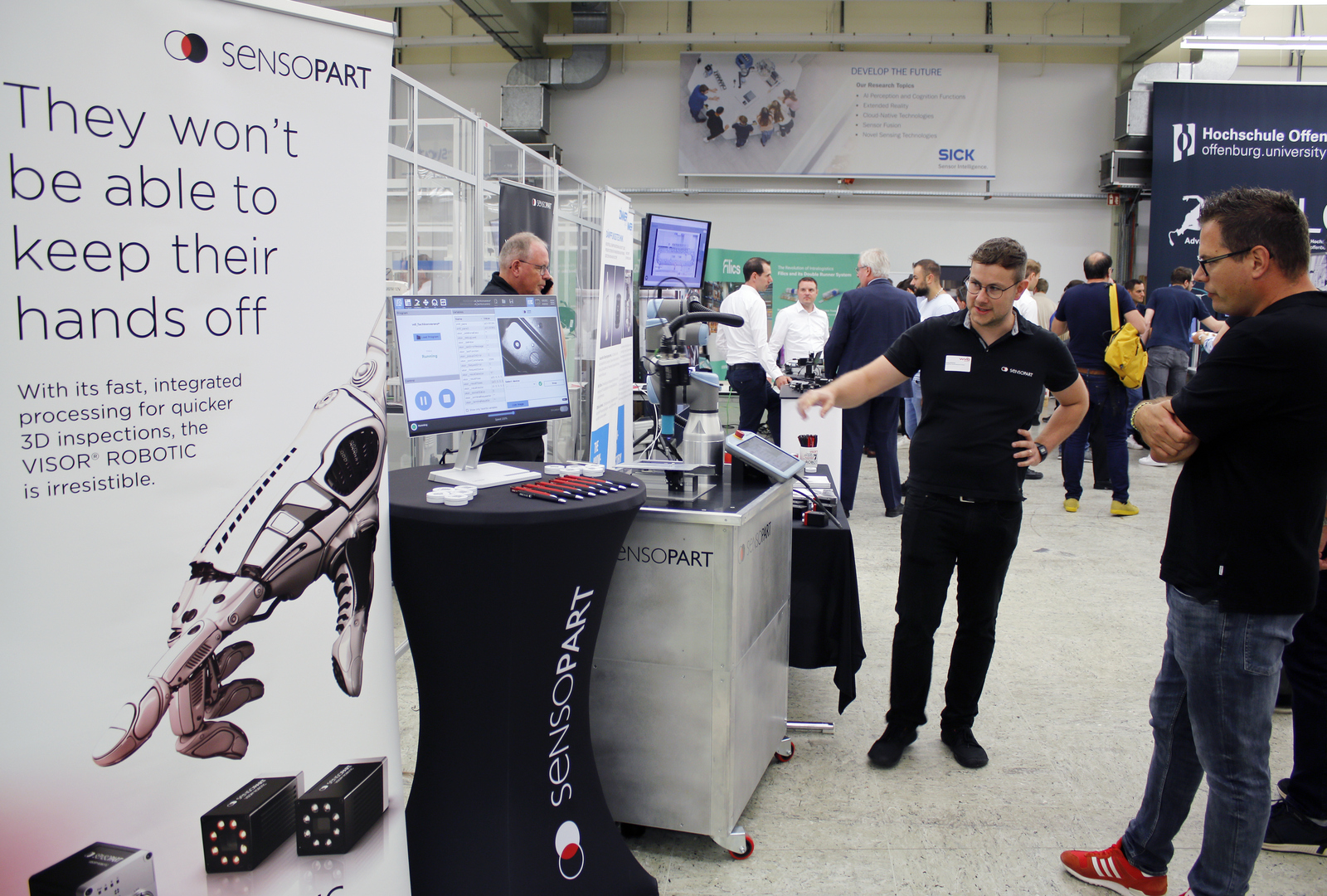 2025-07-15 wvib Robotik Tag Zwei Männer stehen an einem Messestand, einer erklärt etwas