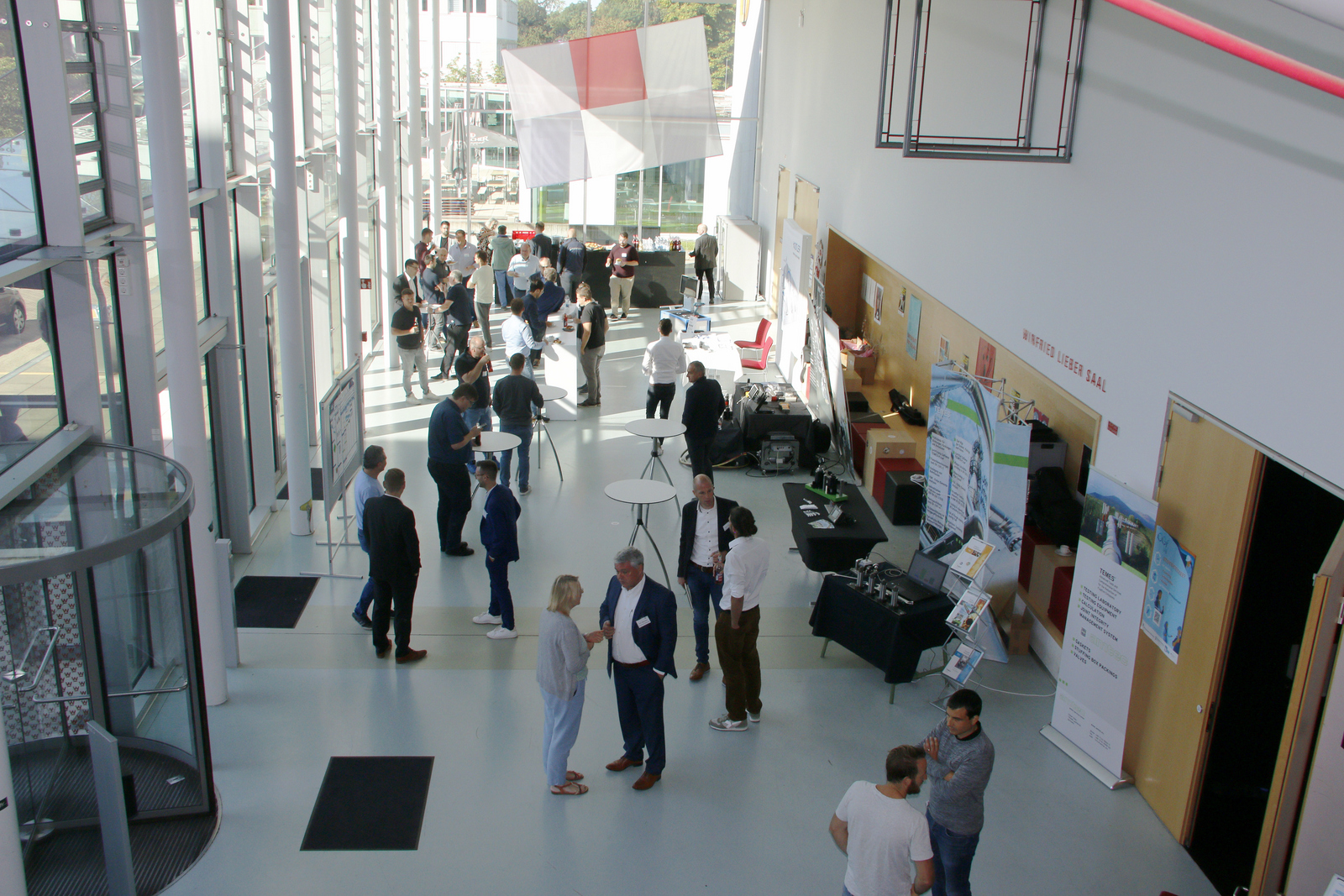 Blick von oben auf Menschen und Firmenstände im Foyer