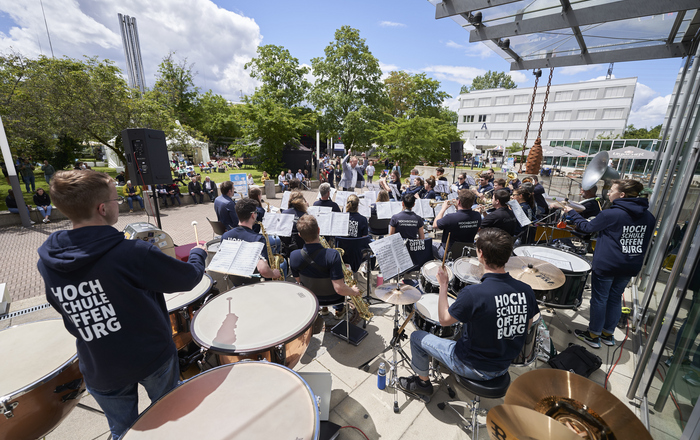Orchester von hinten auf der Treppe von Gebäude D mit Zuschauern davor