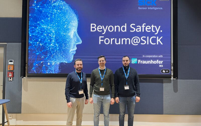 Three men stand in front of a Beyond Safety sign