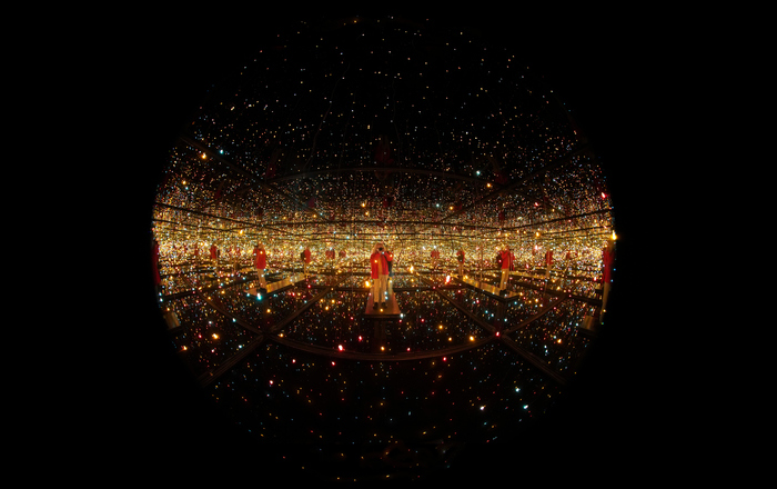 Ein Mann fotografiert sich in einem Kunstwerk selbst