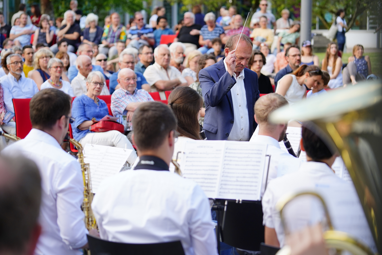 Blick über das Orchester und den Dirigenten auf die Zuschauer