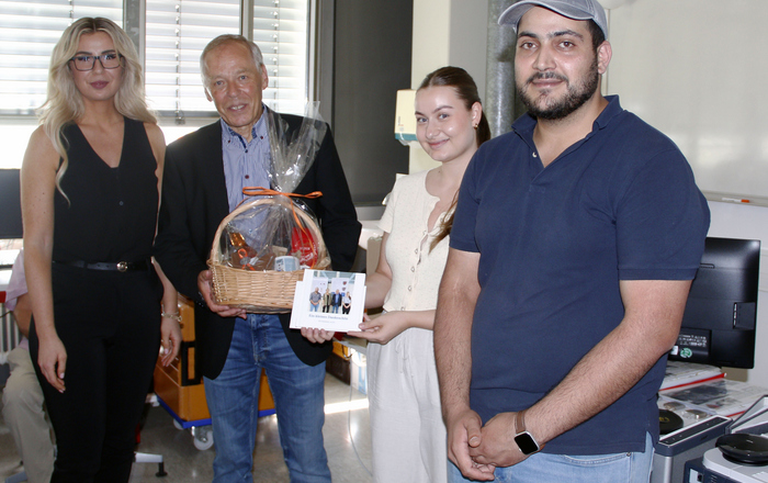 Prof. Dr. Matthias Heinke (2. von links) umrahmt von seinen drei Mitarbeitenden mit Geschenkkorb und Fotobuch