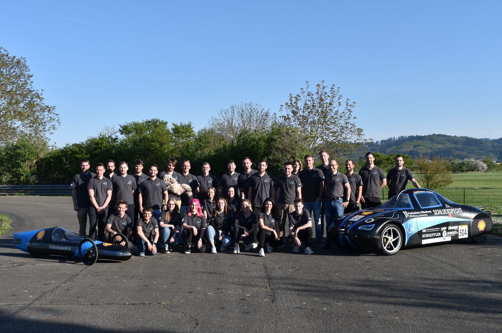 Gruppenbild des Teams mit den beiden Schluckspechten auf der Teststrecke