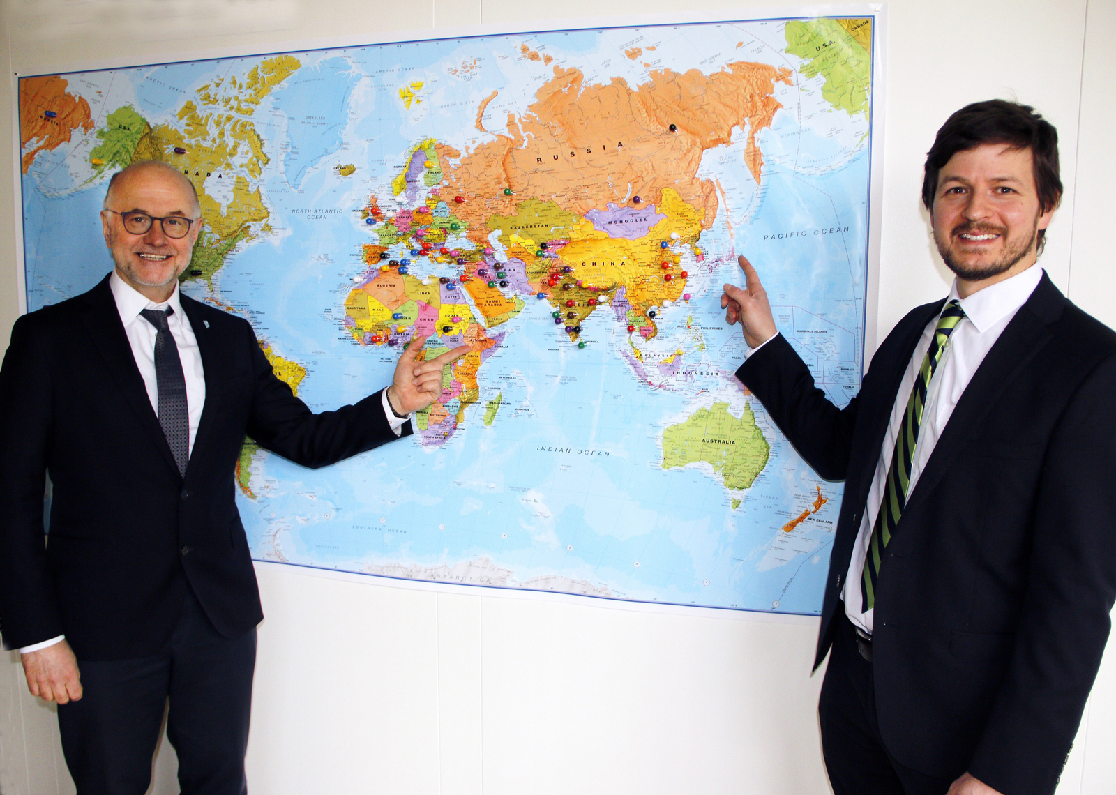 Rektor Lieber und der neue Leiter des International Centers Alexander Burdumy vor einer Weltkarte