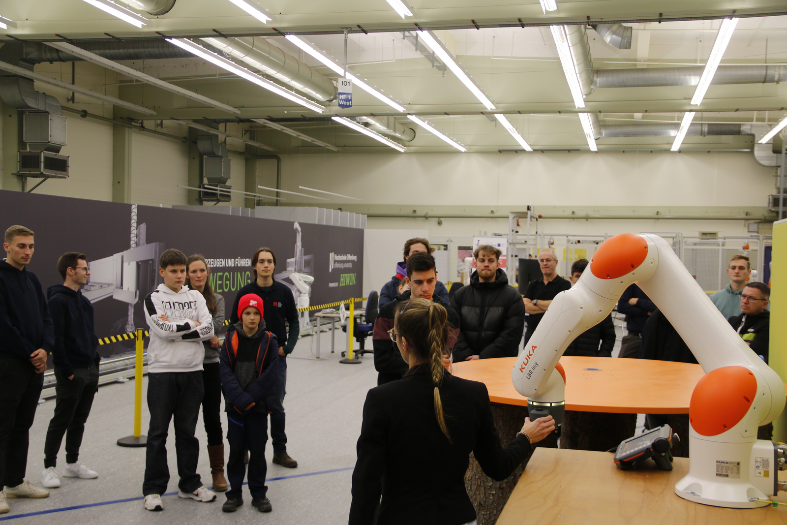 Ein Mitarbeiter von WLRI zeigt einer Gruppe von Studenten einen Roboterarm