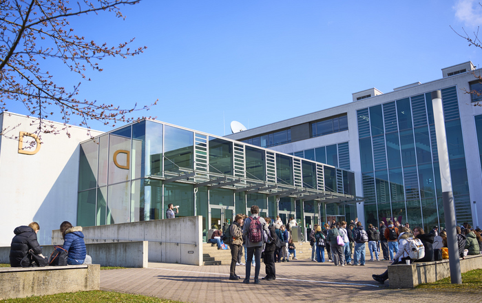 junge Leute stehen vor dem D-Gebäude
