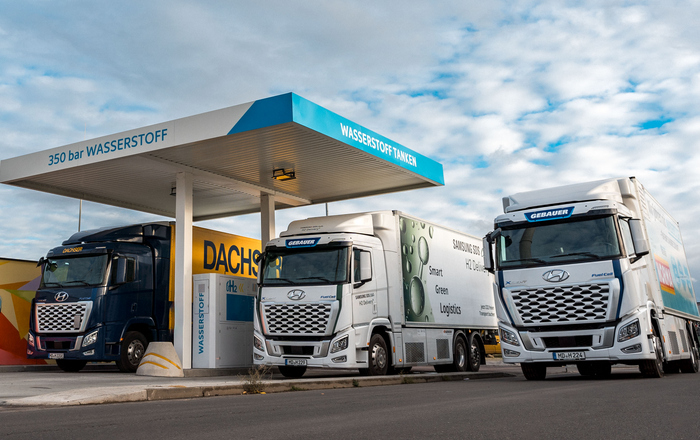Visaulsierung von drei Lastwagen, die an einer Wasserstofftankstelle stehen