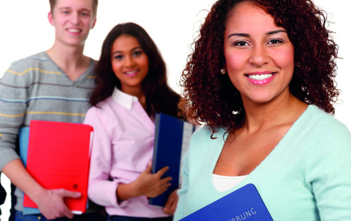 Eine Gruppe junger Menschen mit Bewerbungsmappen