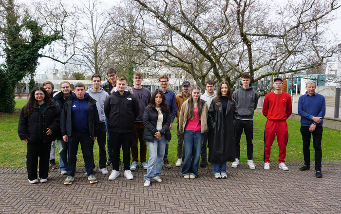 Gruppe aus Studierenden vor blühenden Bäumen auf dem Campus Gelände der Hochschule