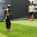 Ein Mann spielt einem humanoiden Roboter auf einem Fußballfeld einen Ball zu.