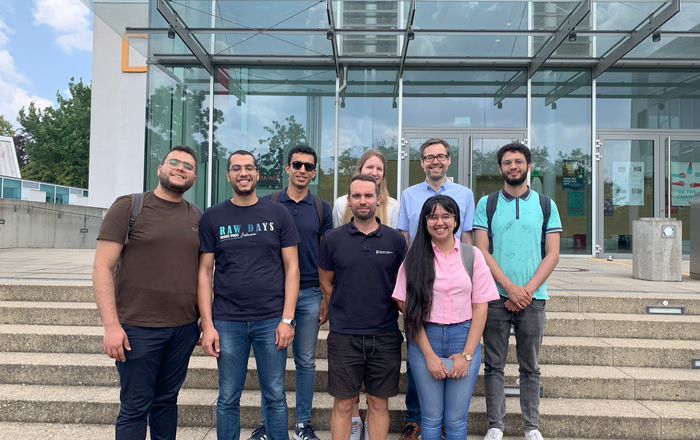 Die Studierenden und ihre Betreuungspersonen mit den DAAD-Referatsleitenden auf der treppe vor dem D-Gebäude