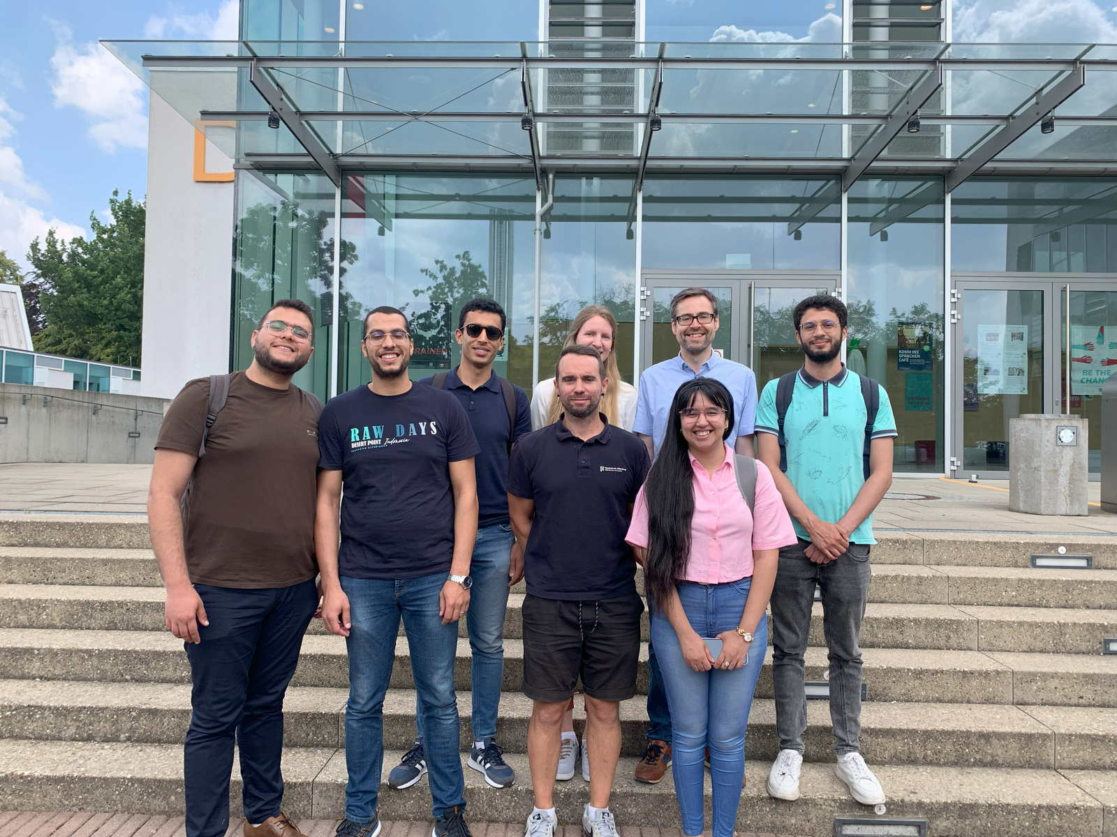 Die Studierenden und ihre Betreuungspersonen mit den DAAD-Referatsleitenden auf der treppe vor dem D-Gebäude
