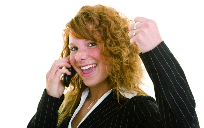 Eine Frau telefoniert und ballt gleichzeitig die Siegerfaust