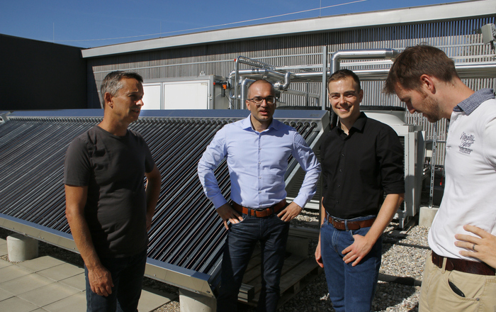 Die vier Herren vom Green Office vor der Solarthermieanlage auf dem RIZ Energie