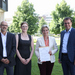Prof. Dr. Tobias Hagen, Prof.in Dr. Simone Braun, Ministerin Dr. Nicole Hoffmeister-Kraut und Kultus-Staatssekretär Volker Schebesta (von links) stehen auf dem Rasen vor dem Ministerium. Die Ministerin hat den Bewilligungsbescheid in den Händen