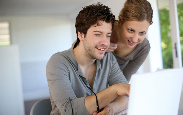 Eine Mann und eine Frau schauen auf einen Laptop