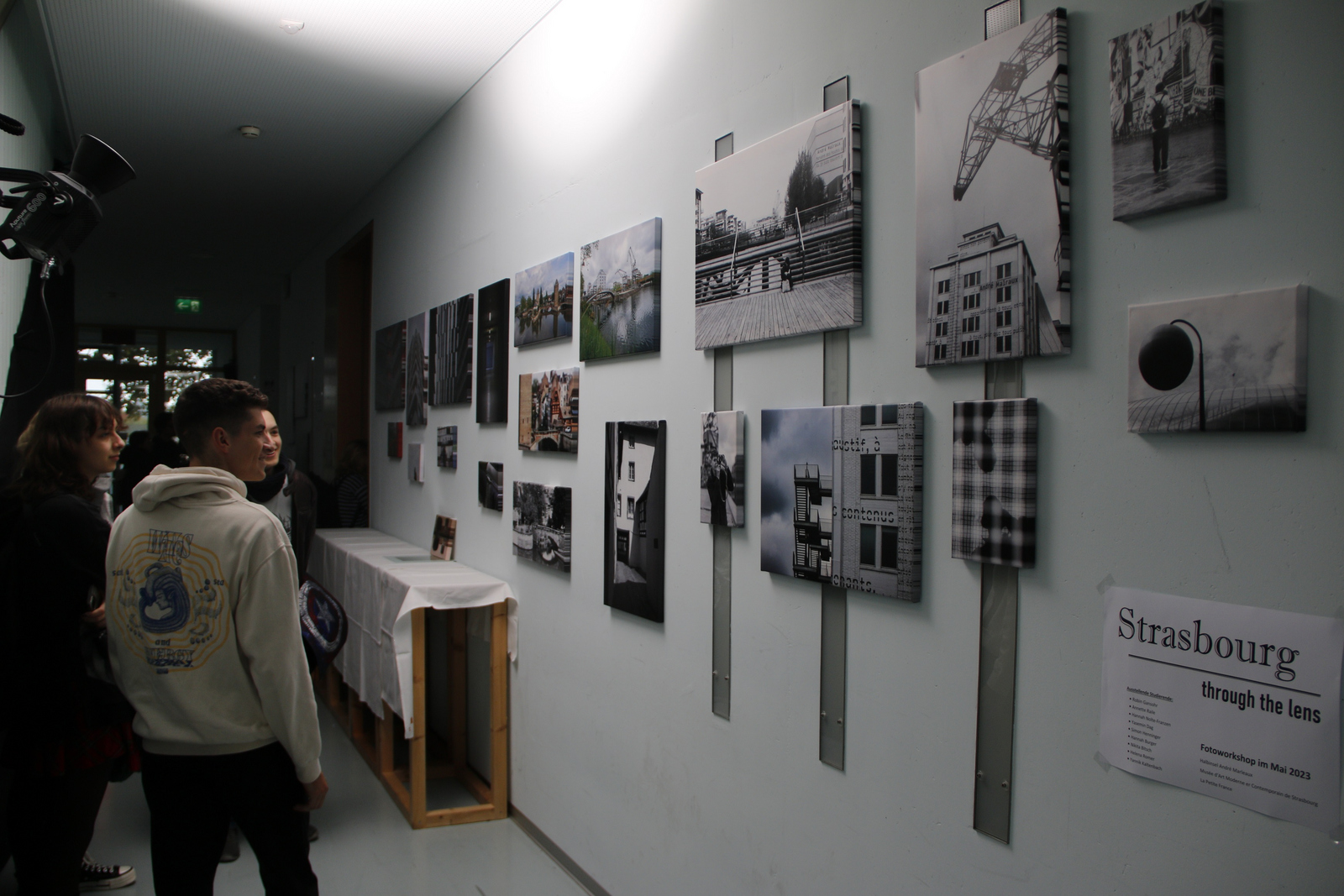 Menschen betrachten Straßburg-Fotografien an der Wand