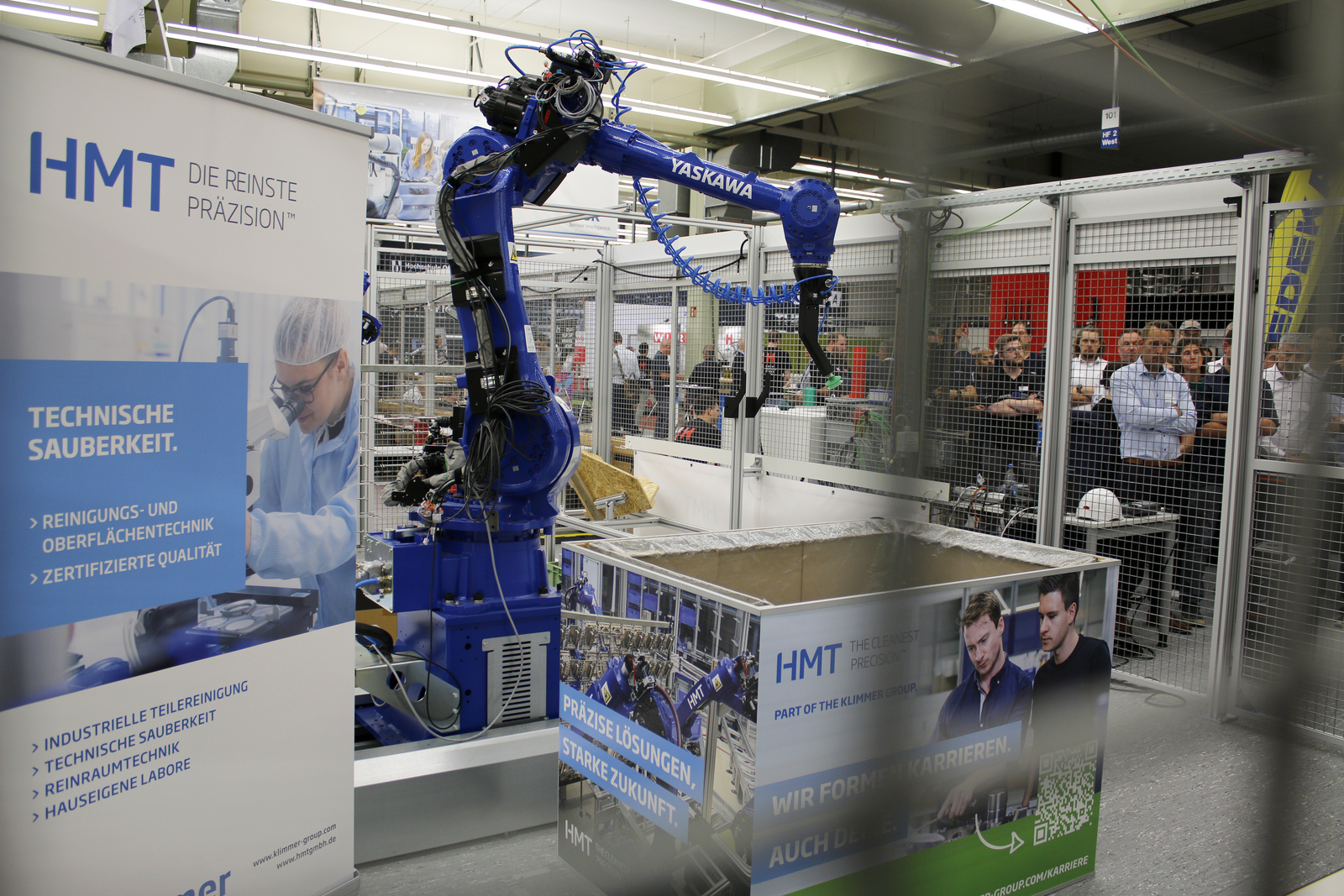 2025-07-15 wvib Robotik Tag Menschen Stehen außerhalb einen Käfigs und beobachten den Roboterarm darin