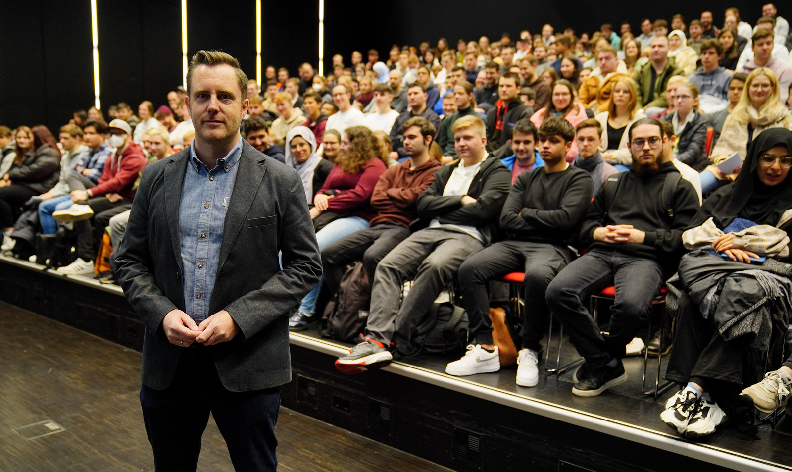 Prorektor Prof. Dr. Oliver Schäfer steht im Winfried-Lieber-Saal vor den mit Erstsemestern vollbesetzten ansteigenden Stuhlreihen