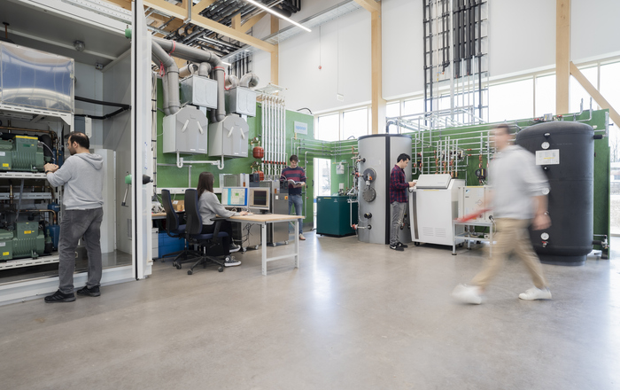 Menschen in einem Technikum arbeiten an einer Heizungsanlage