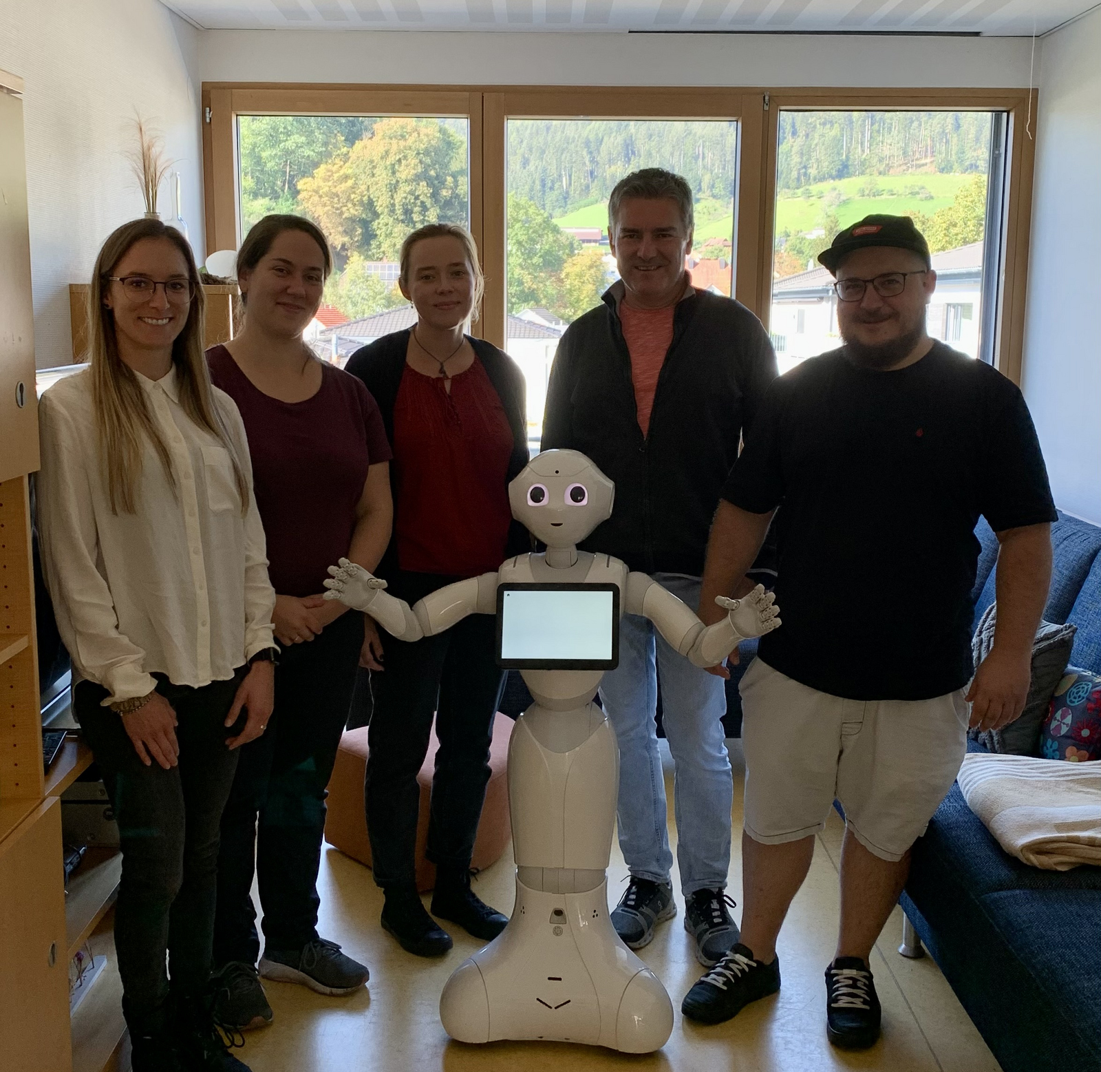 Besucher und Mitarbeiter mit dem Roboter Pepper