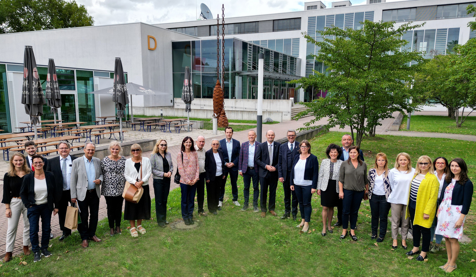 Gruppe auf dem Rasen vor dem D-Gebäude