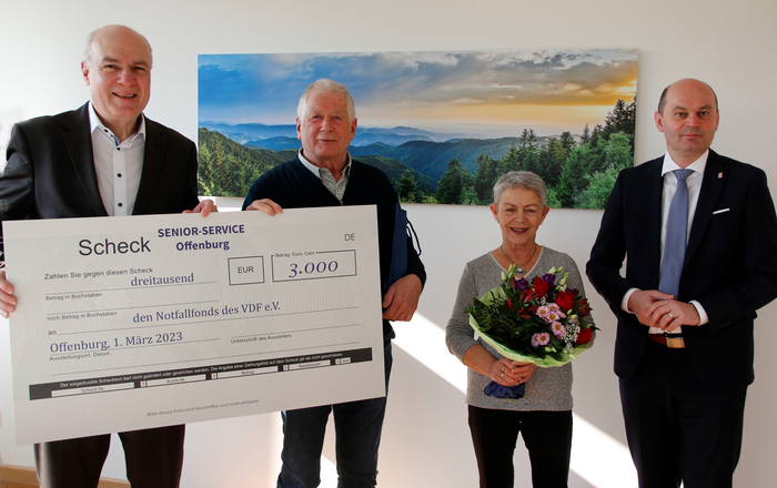 Gruppenfoto mit Spendenscheck vor Schwarzwaldbild