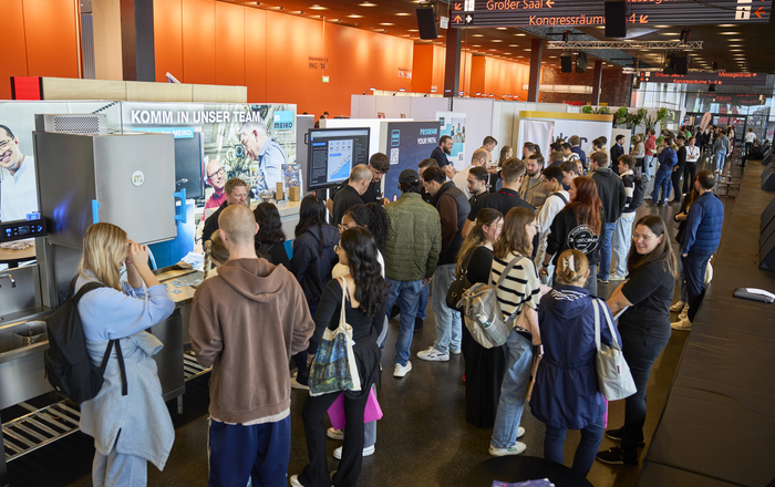 2025-10-21 PM Career Messe Junge Leute an Messestände in einer Kongresshalle