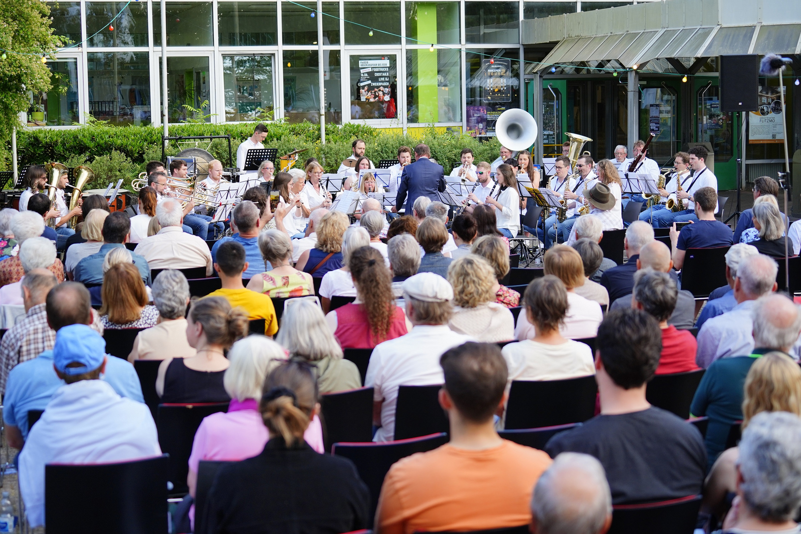 Blick übers sitzende Publikum auf das spielende Hochschulorchester