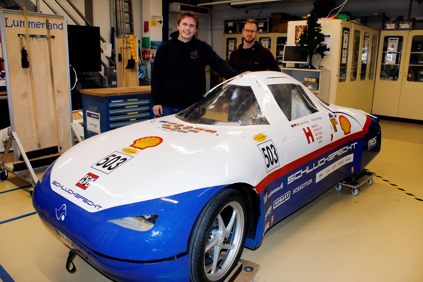 Zwei junge Männer stehen neben eine Auto